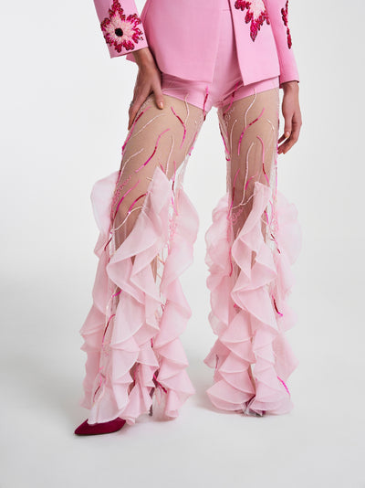 Close-up of pink ruffled trousers showcasing intricate embroidery and flowing sheer fabric