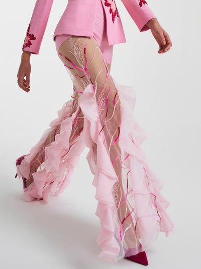 Side view of sheer trousers with cascading ruffles, making a bold couture statement