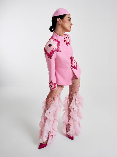 Sheer pink trousers with artistic ruffles and embroidery, styled for high-fashion occasions